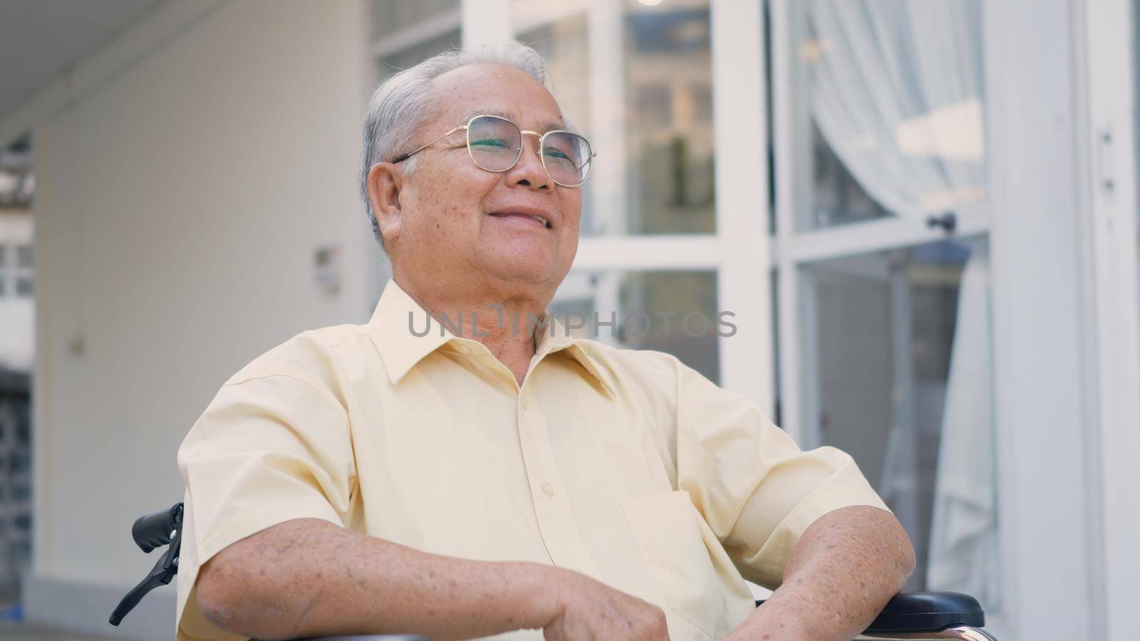 Disabled senior man sitting on wheelchair alone in rehabilitation center, Portrait happy Asian generation outdoors backyard at home, closeup face smiling