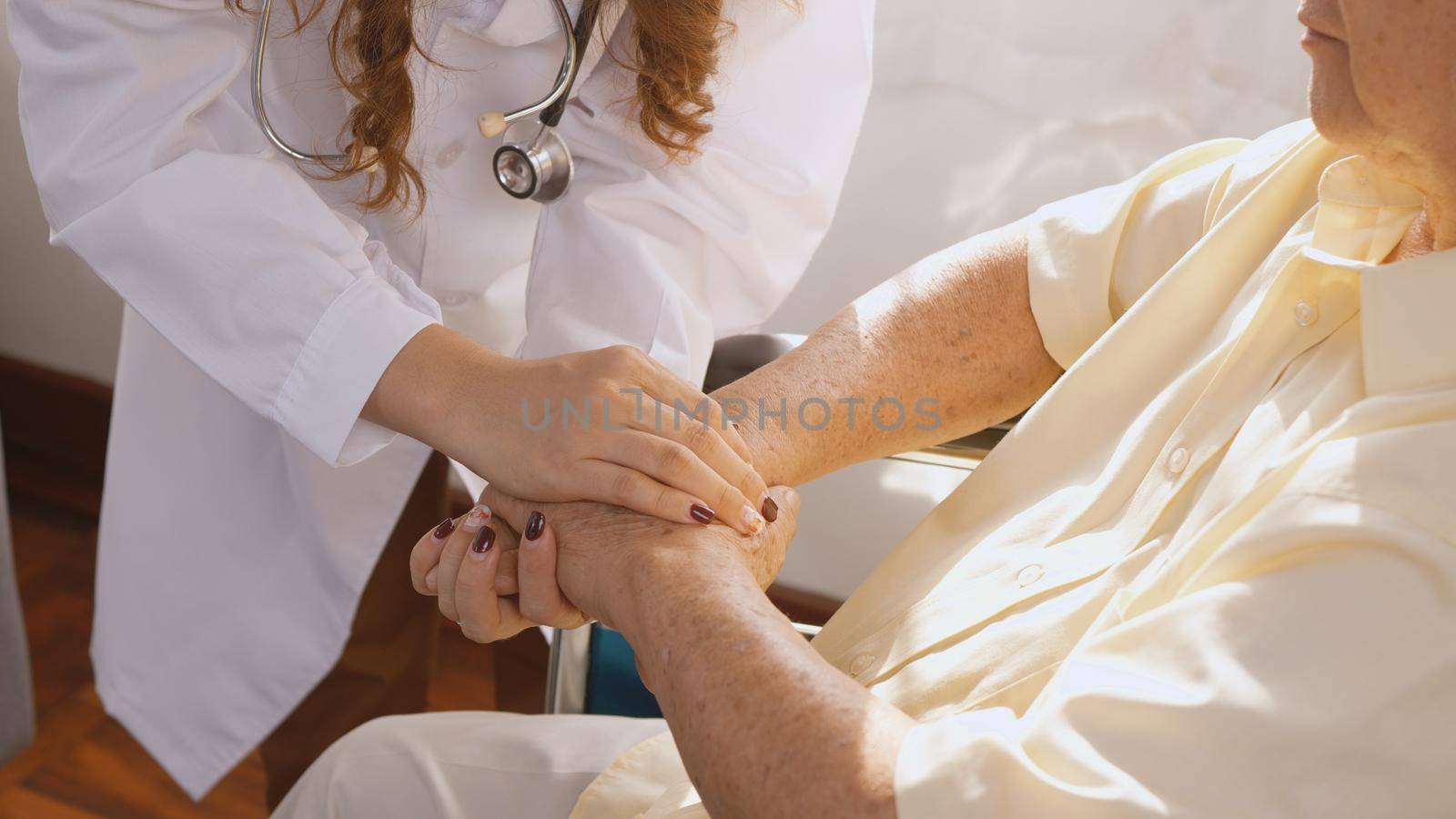 doctor wear white uniform holding hand of patient senior or elderly old man during sit on wheelchair encourage and empathy by Sorapop