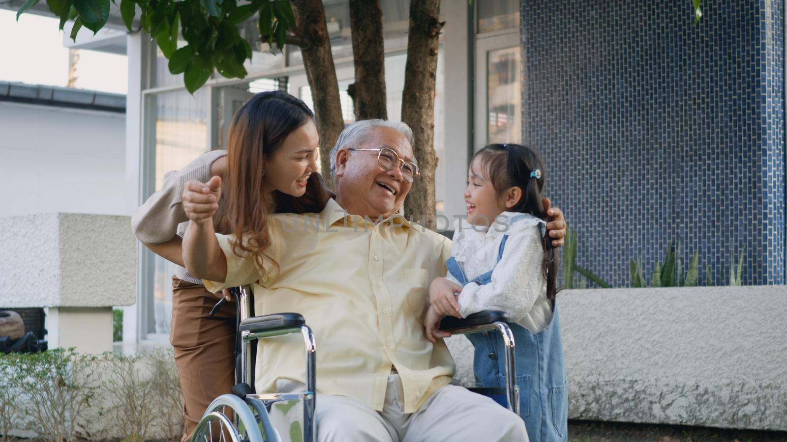 Disabled senior grandpa on wheelchair with grandchild and mother in park by Sorapop