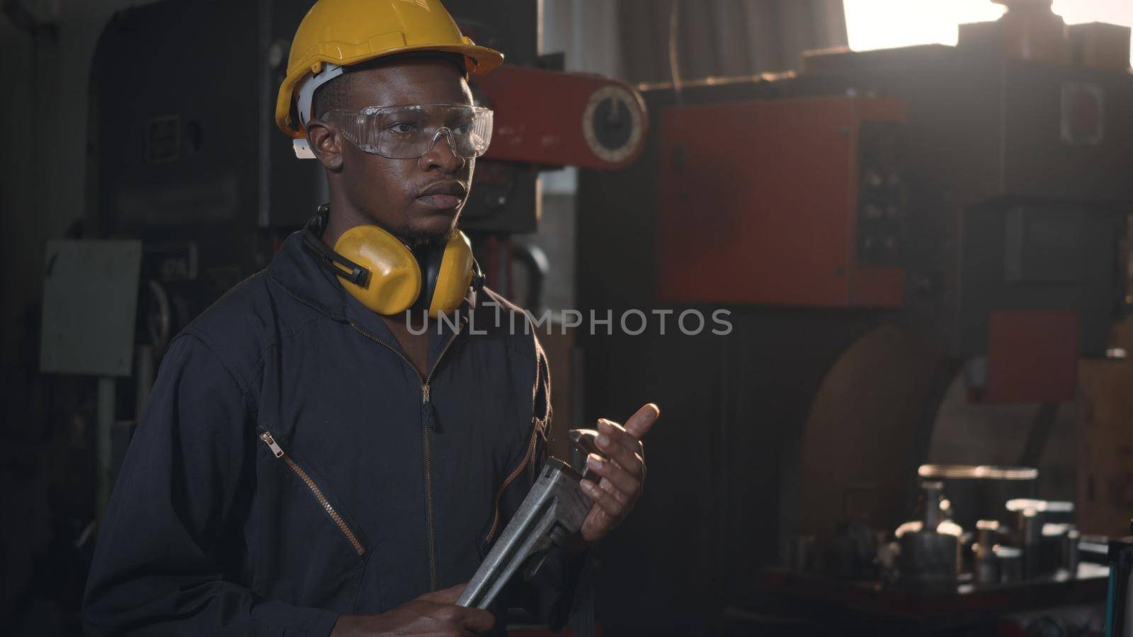 Engineer standing holding wrench on his hand at work in industry factory by Sorapop