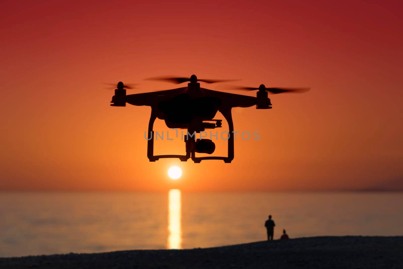 Silhouette of a quadrocopter on sunset background