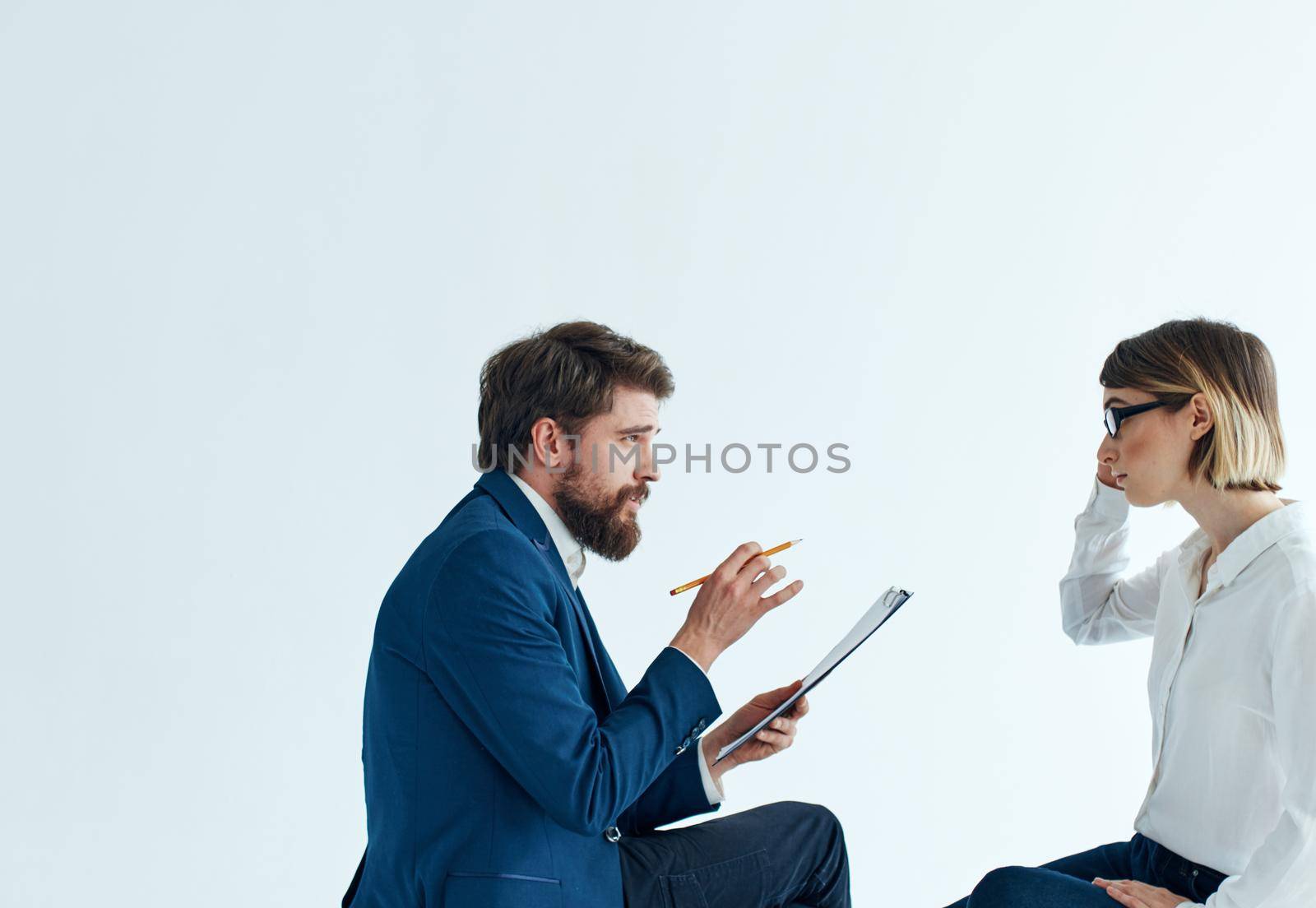 Woman and man are sitting on the couch in suits psychology papers by SHOTPRIME