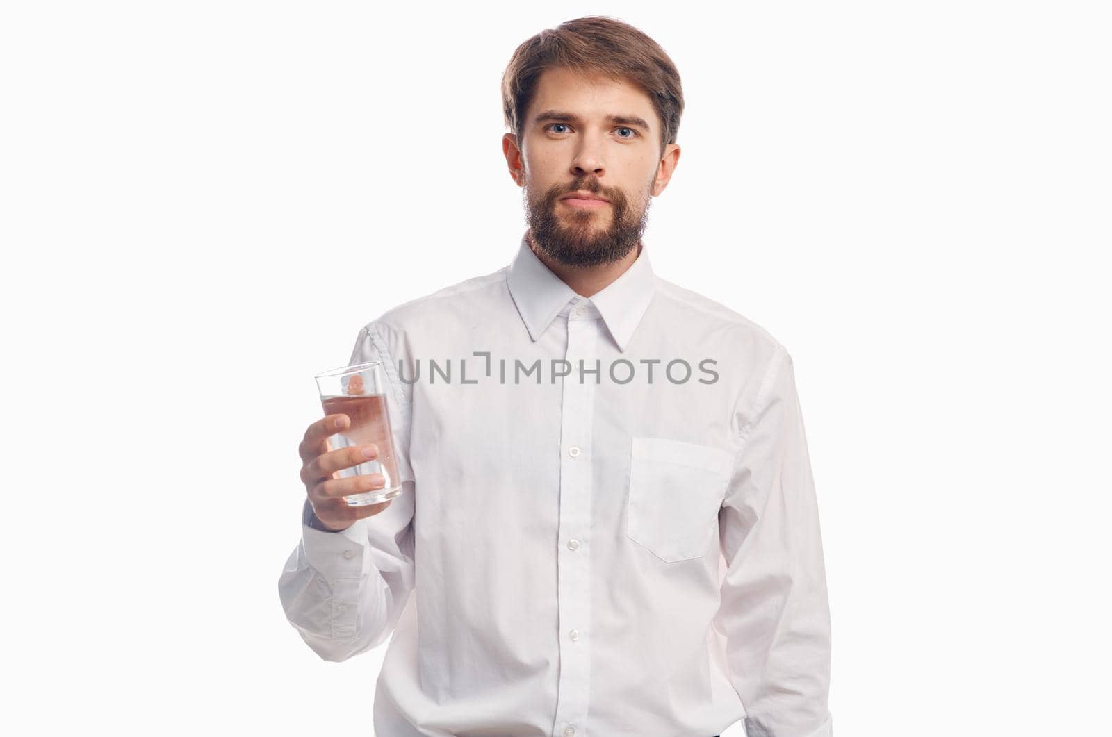 handsome man with glass of water healthy lifestyle white shirt light background. High quality photo