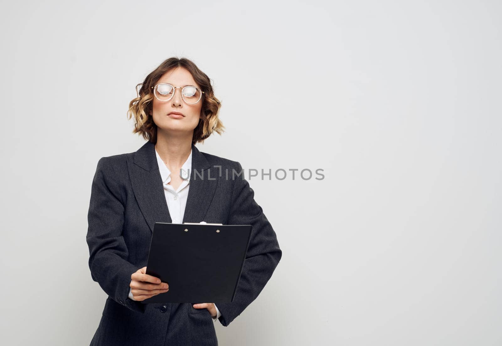 Woman with a folder of documents in her hands on a light background Copy Space. High quality photo