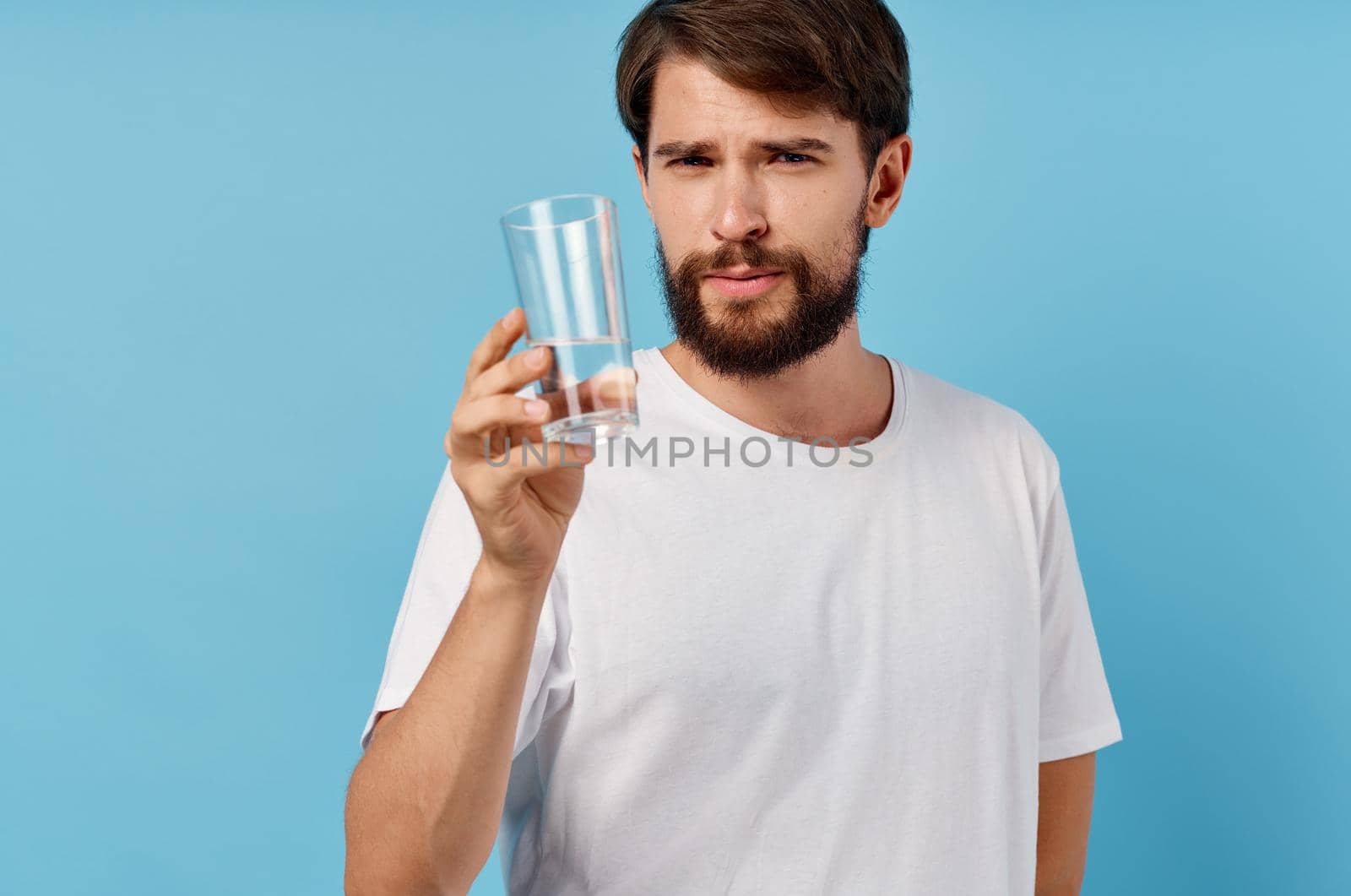 happy man with glass of water on blue background drink lifestyle. High quality photo