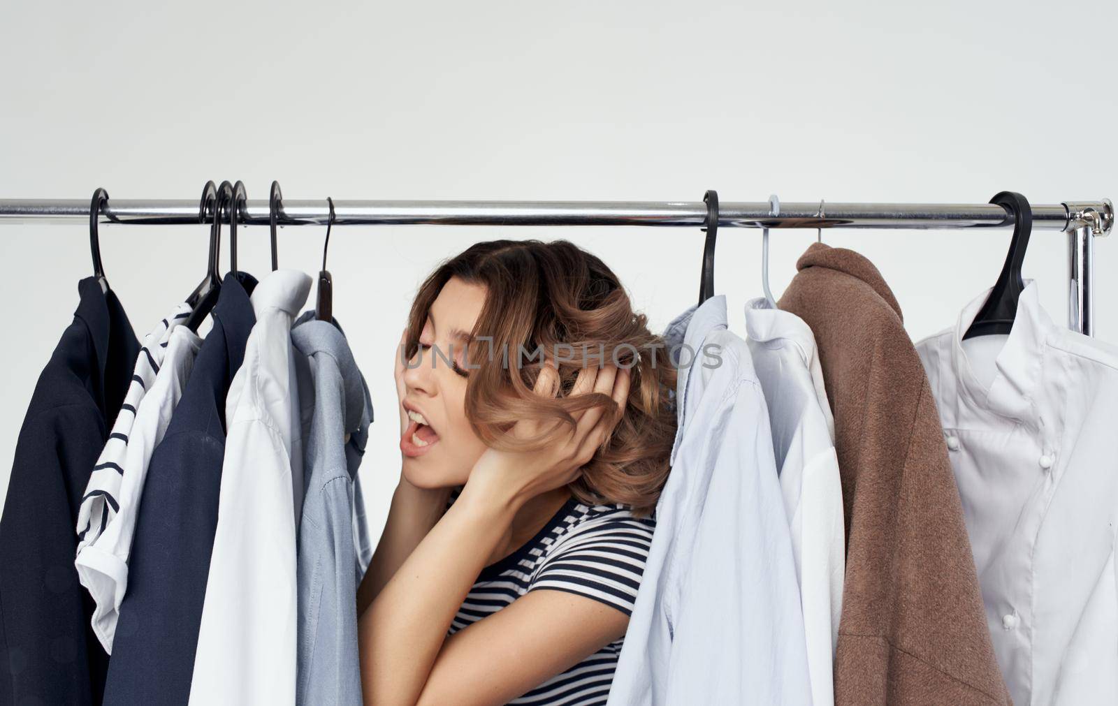 Woman in fitting room with clothes in hand shopping shirt by SHOTPRIME
