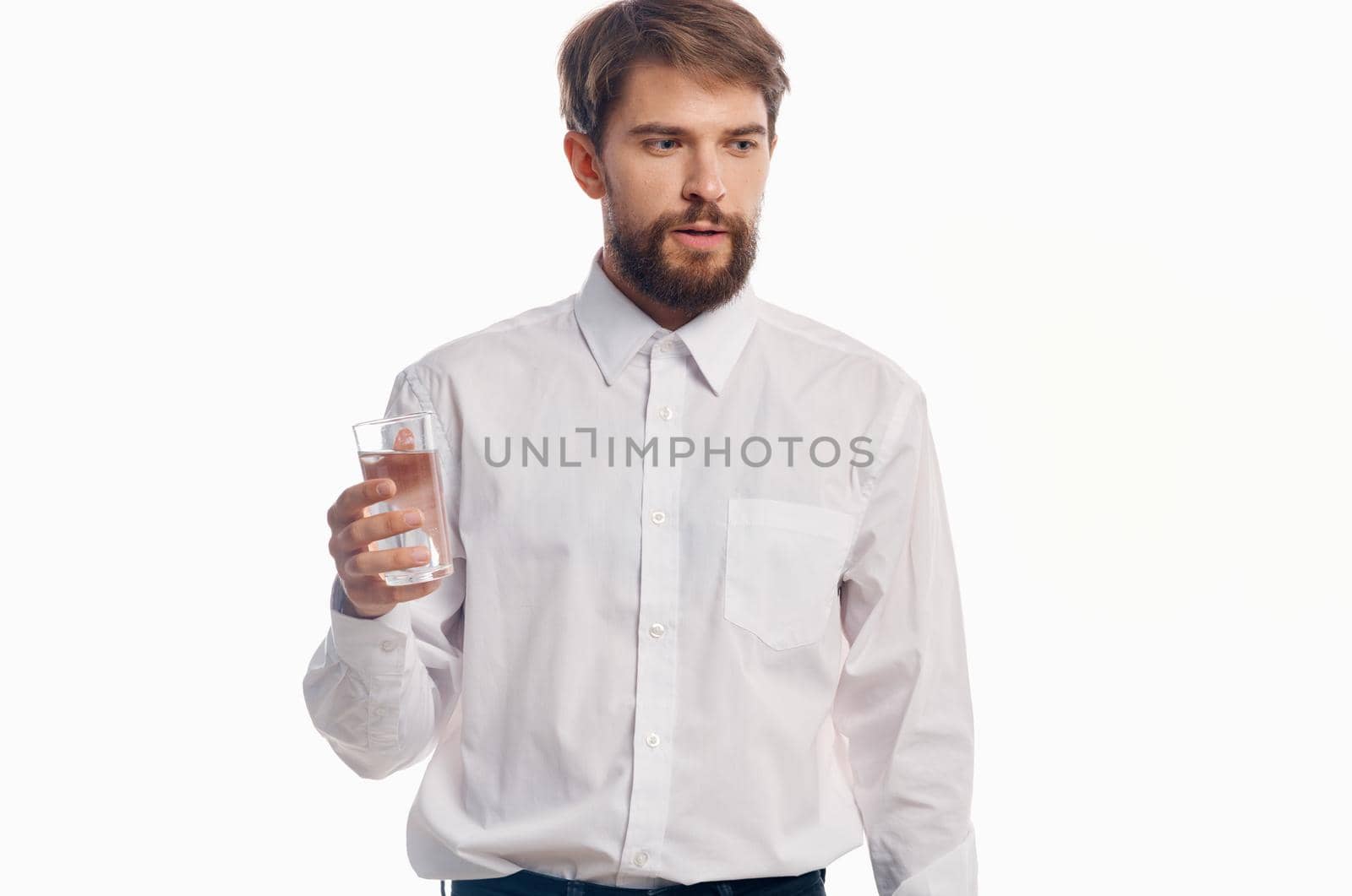 handsome man with glass of water healthy lifestyle white shirt light background by SHOTPRIME