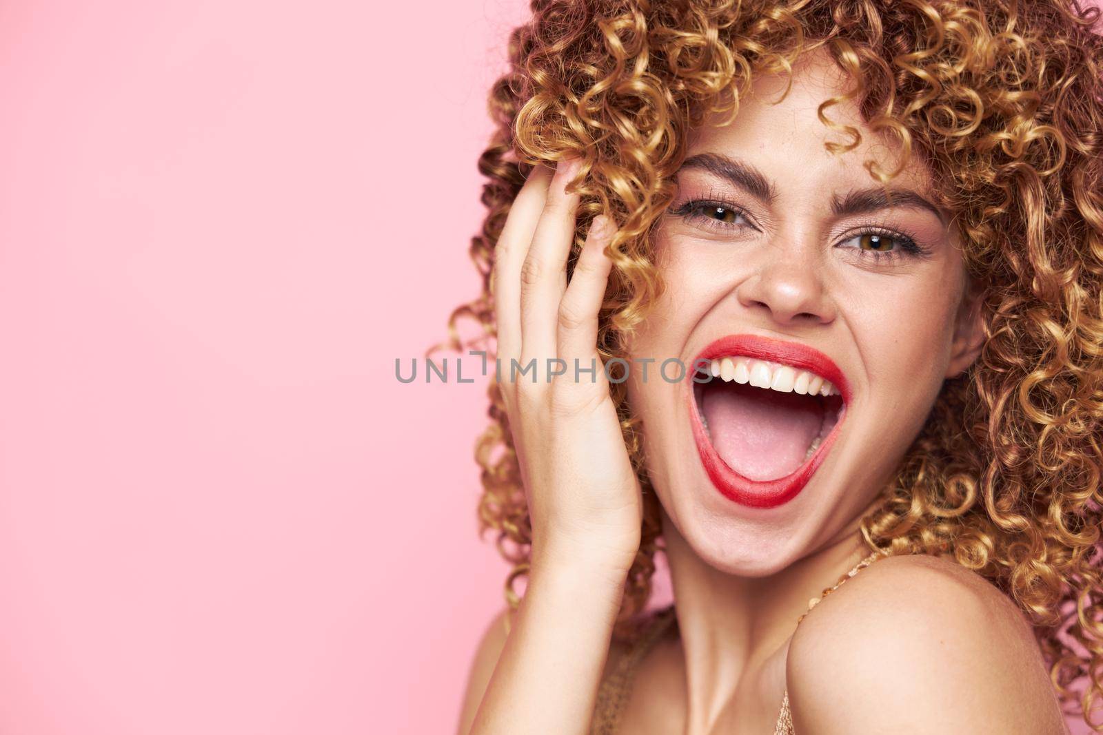 Charming model Energetic appearance wide open mouth emotions curly hair pink isolated background