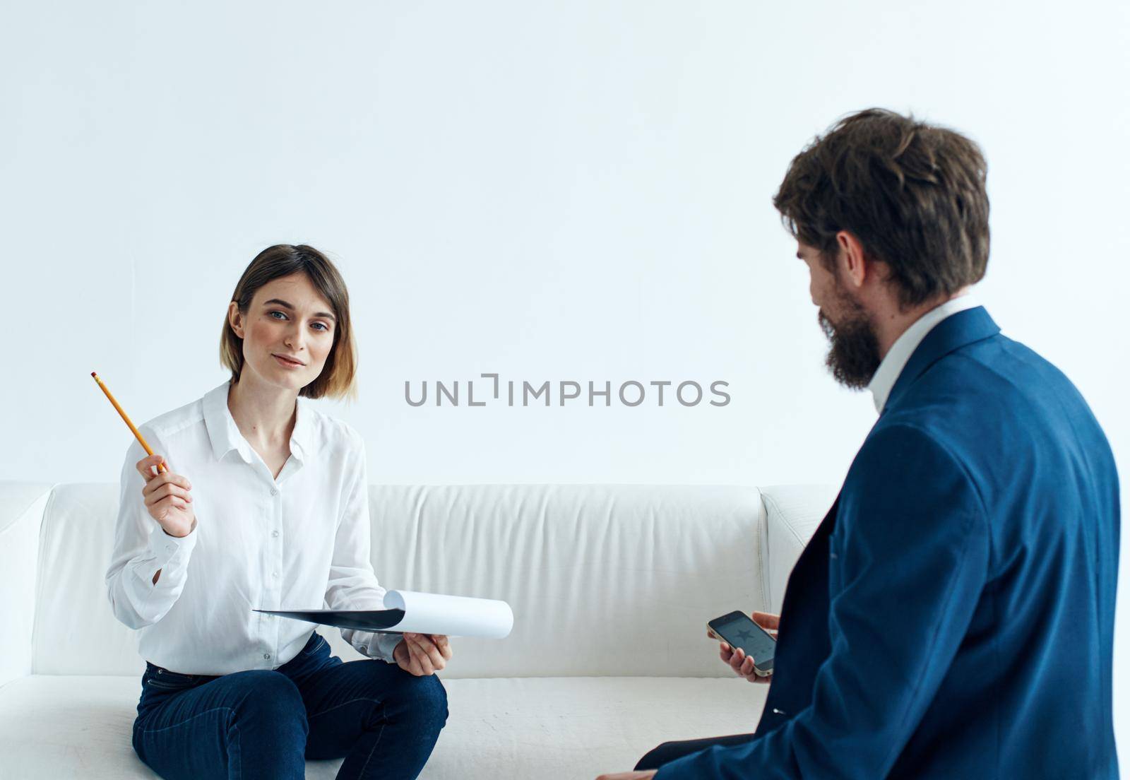 Woman on sofa indoors psychologist communicating and man in suit. High quality photo