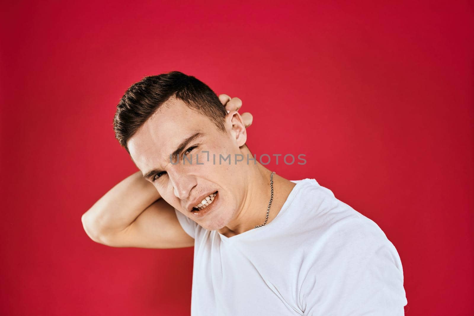 Emotional man white t-shirt displeased facial expression red isolated background cropped view by SHOTPRIME