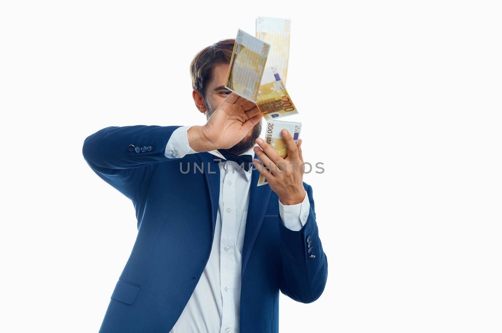 happy man scatter money on light background suit model business finance. High quality photo