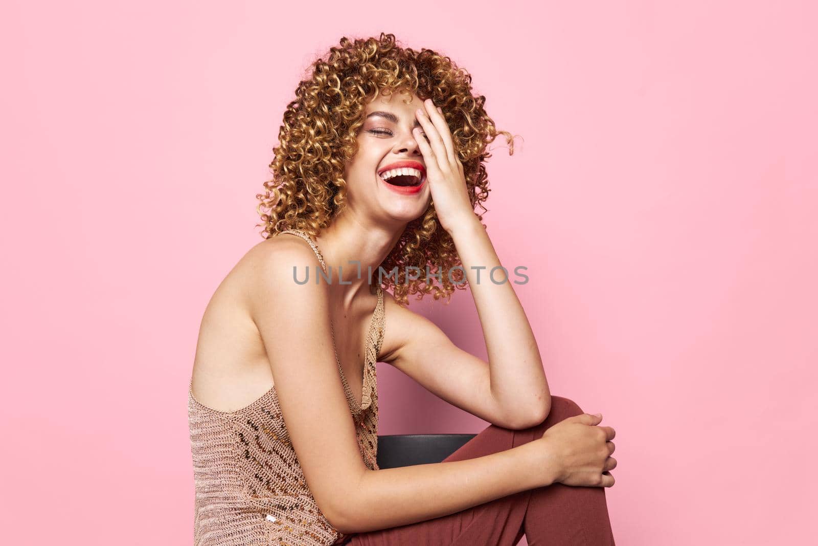 Attractive woman Curly hair sits on a chair smile happiness bright makeup isolated background