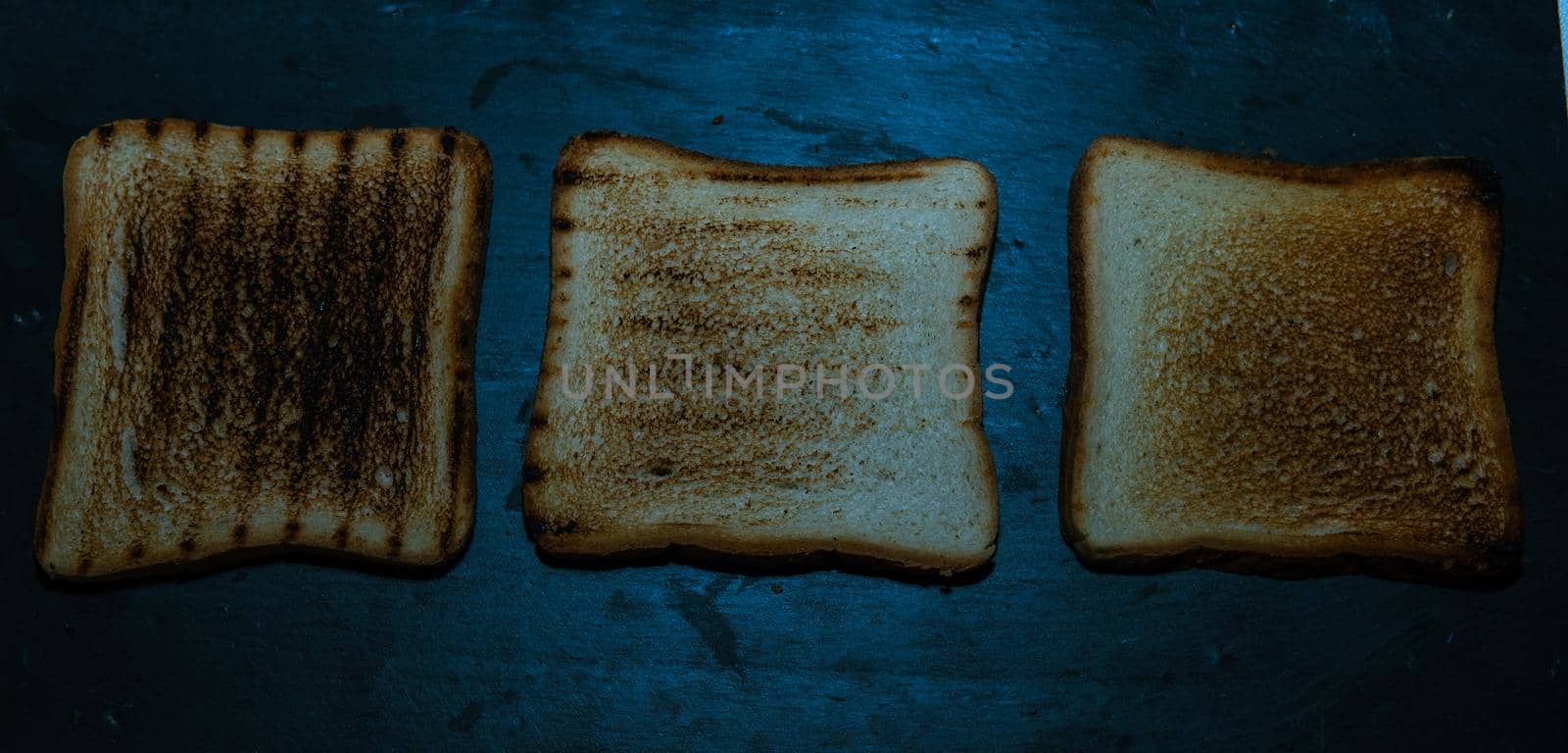 Three slices of toasted bread on a black background