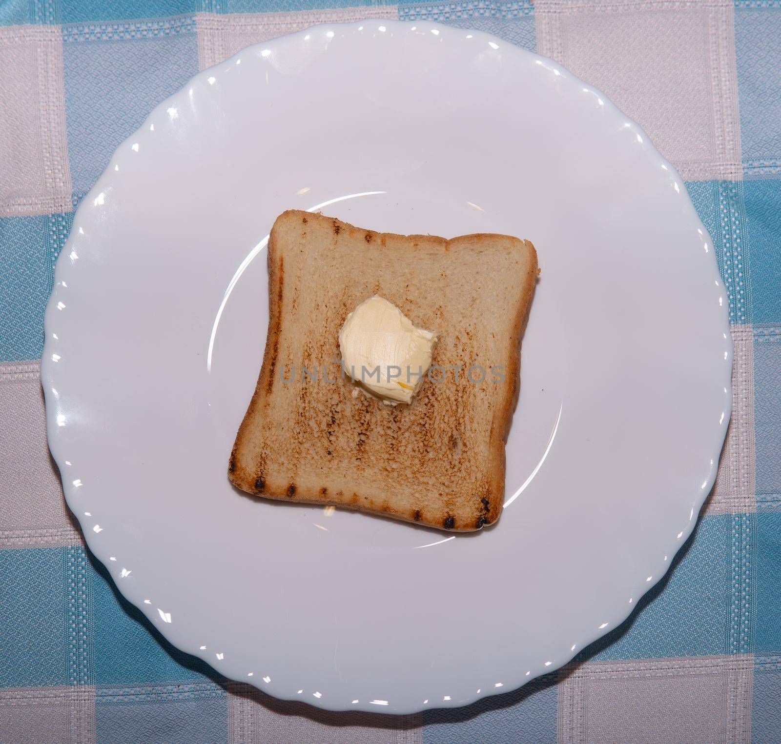 Toasted bread with butter on a white plate by xavier_photo