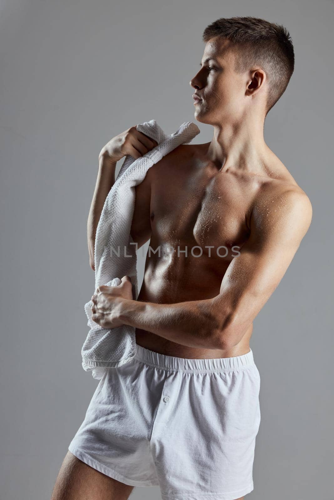 man with towel in white shorts athlete bodybuilder isolated background by SHOTPRIME