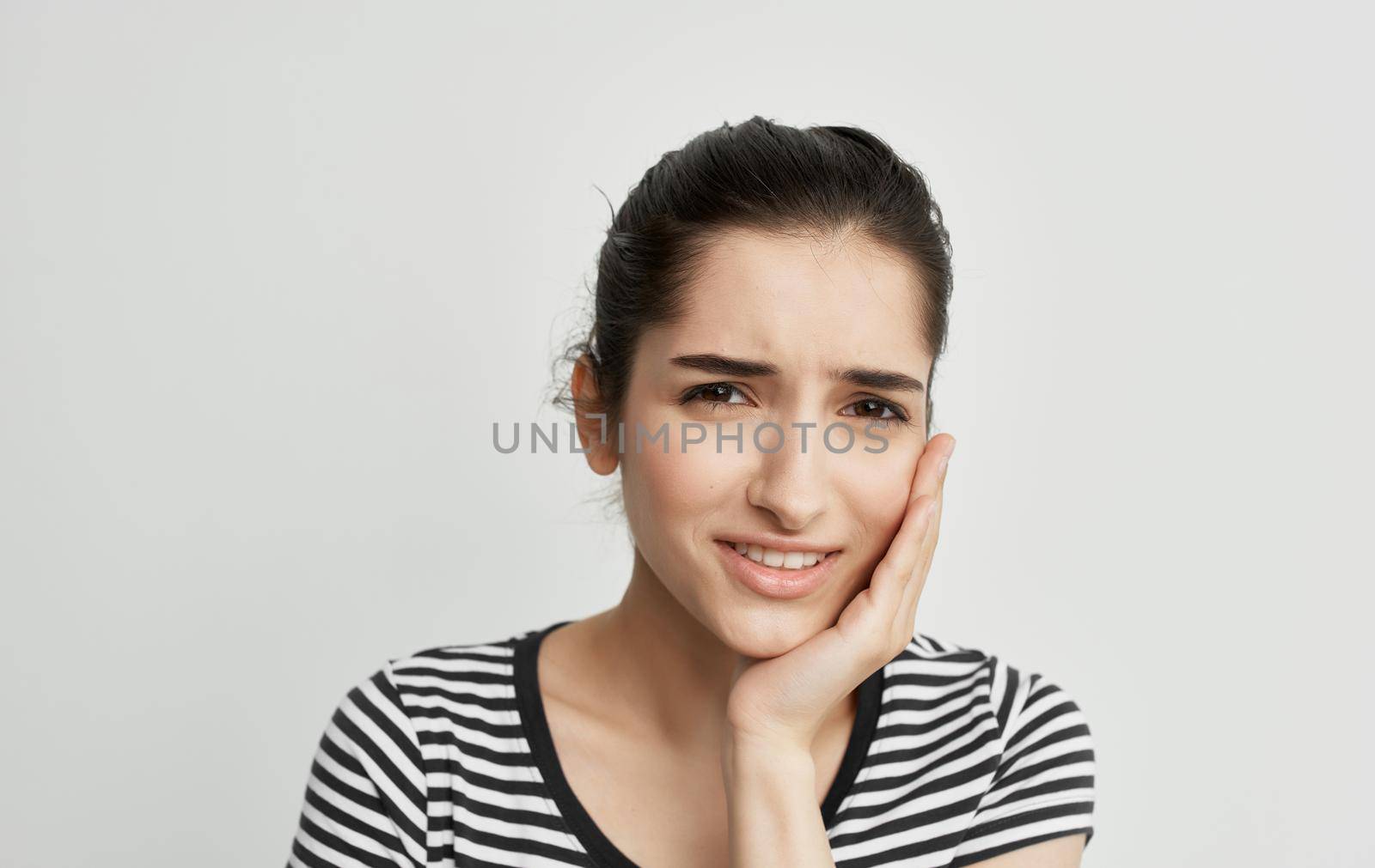 woman in striped t-shirt holding face dental problems pain discontent. High quality photo