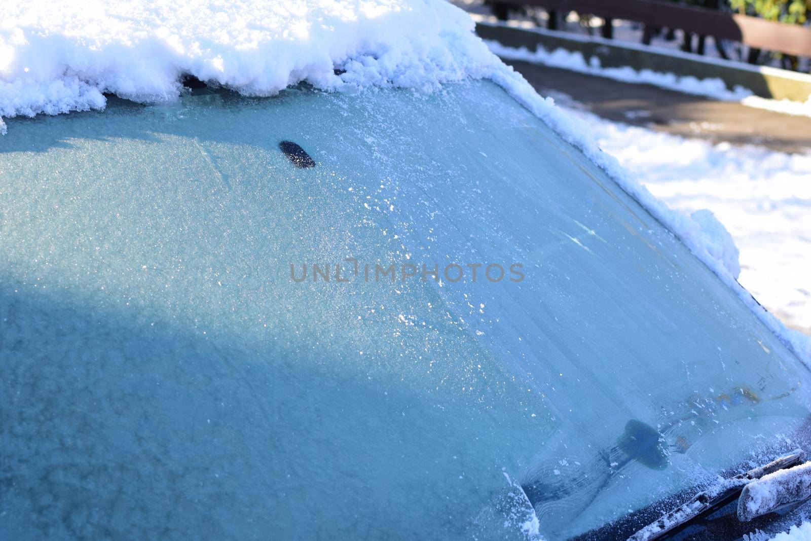 Iced snow on a car roof in the sunlight as a close-up