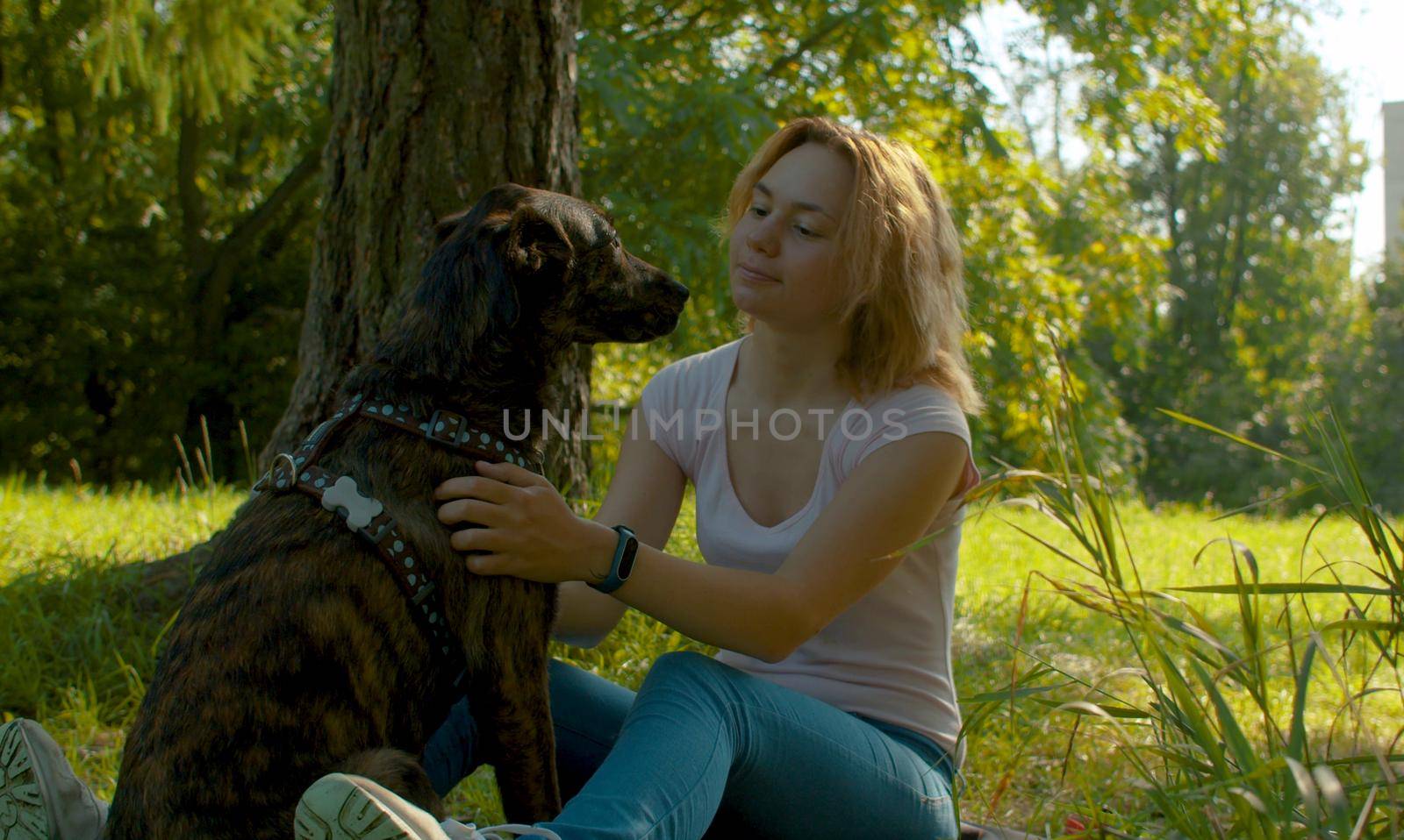 Two best friends - attractive young lady and her dog in the park.