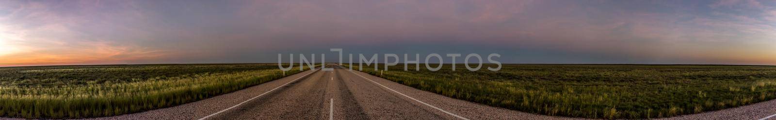 panorama of a straight road through the outback of Australia, after a beautiful sunset