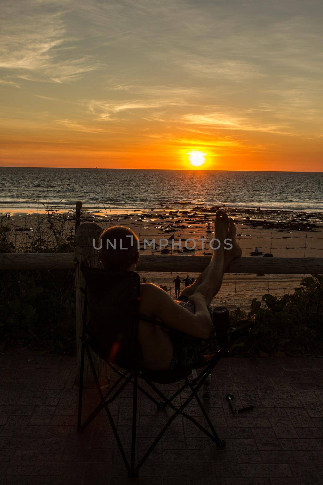 Man relax on chair beach in vacations with sunset having dinner