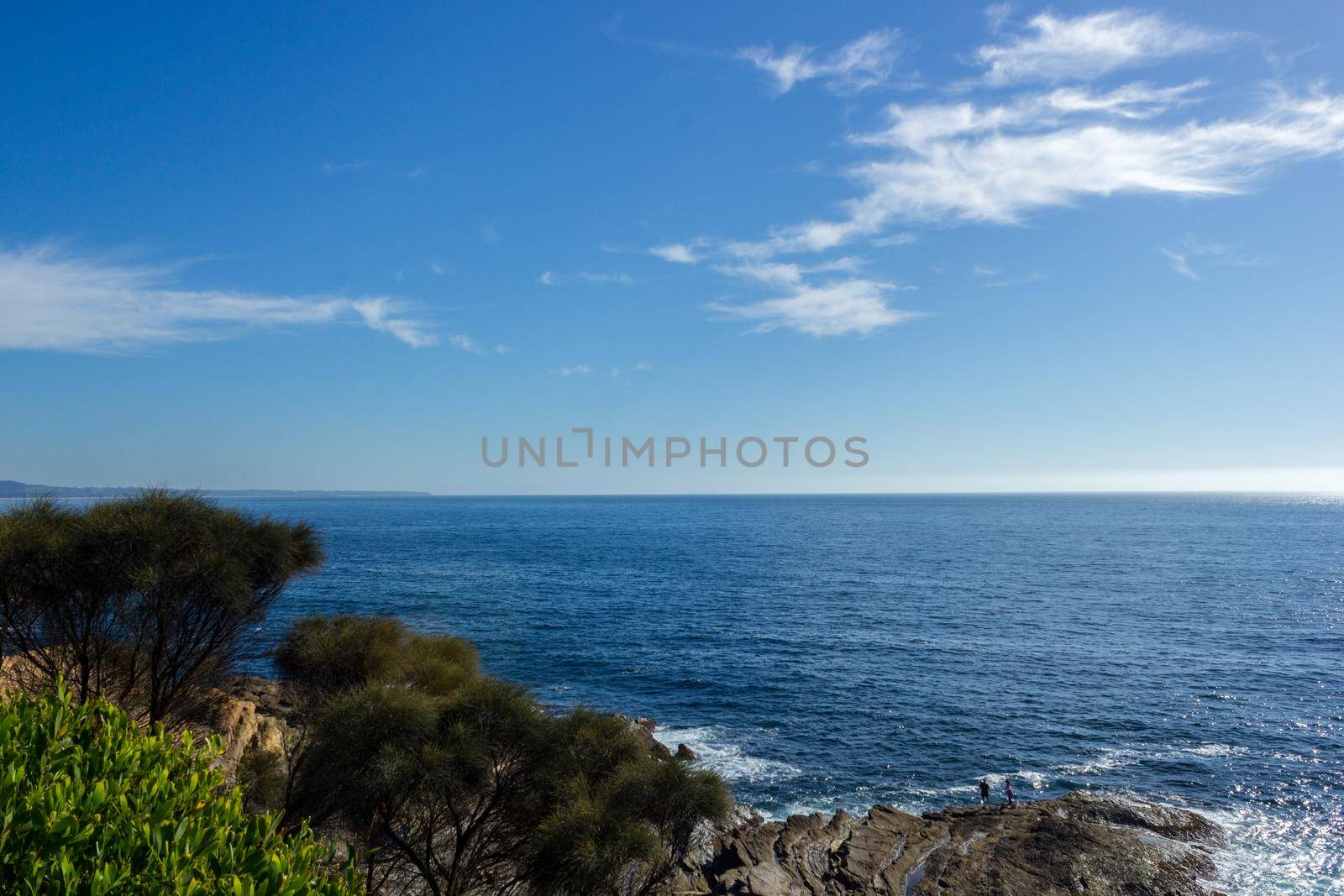2 People on a Coastline with ocean and rocks, NSW, Australia