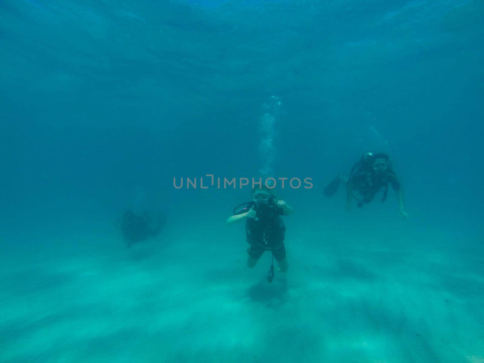 GREAT BARRIER REEF, AUSTRALIA - OCT 13, 2015: 3 Scuba diving tourist are swimming at the great barrier reef