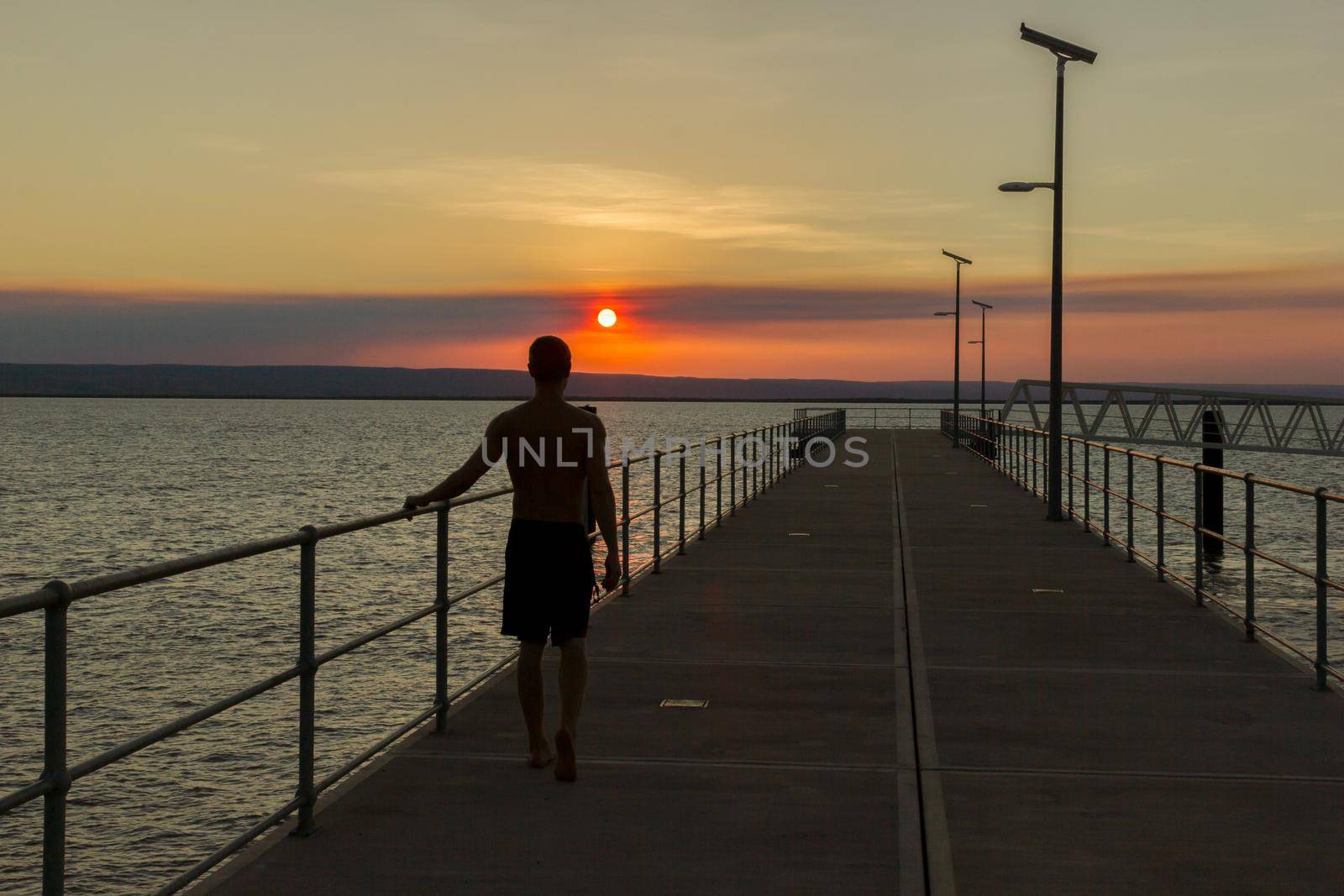 young man walking on a yetty with beautiful sunset