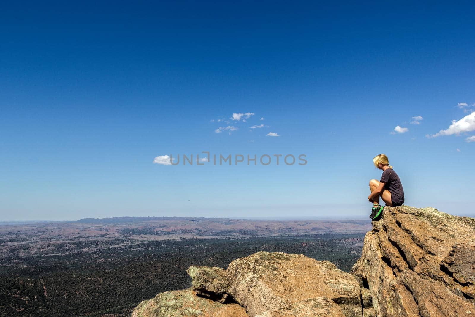 jung women sitting on St Mary's Peak from the Flinders Ranges National Park by bettercallcurry