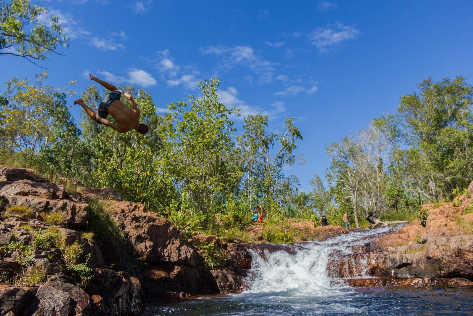 young man doing a salto in the Buley Rockhole in Litchfield National Park, Northern Territory, Australia by bettercallcurry
