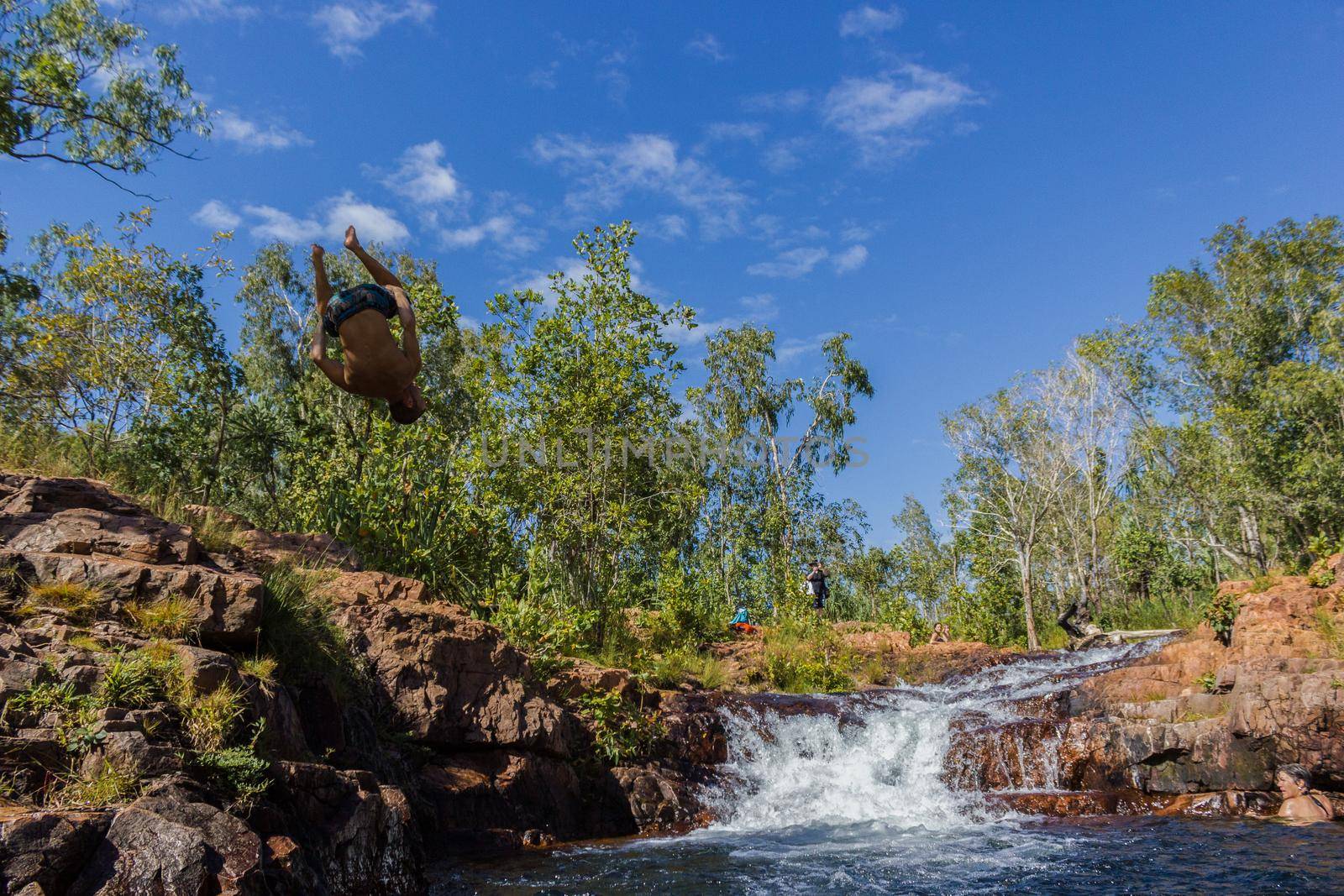 young man doing a salto in the Buley Rockhole in Litchfield National Park, Northern Territory, Australia by bettercallcurry