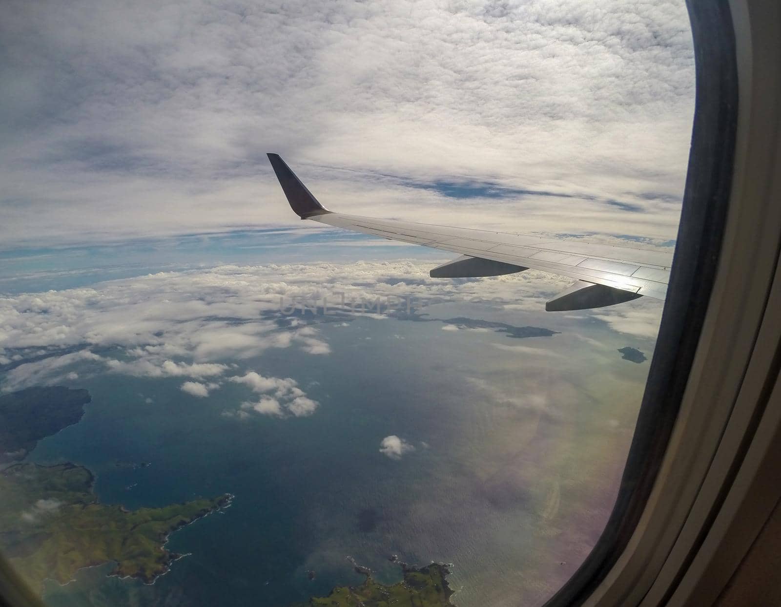 Aerial Landscape View of the Mountain Tropical Coastline Beach of Nadi Airport, Fiji in the South Pacific from Inside an Airplane.