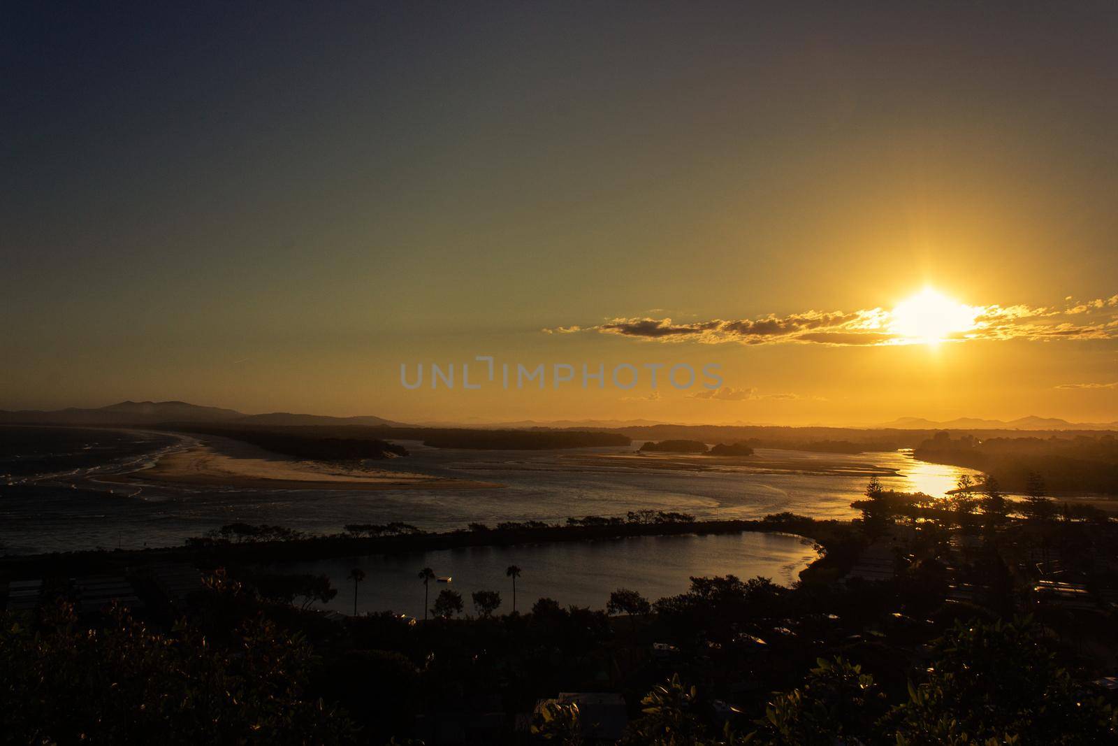 Flat sand dunes at delta of Nambucca river entering Pacific ocean through wide sandy beach of Australian coast around Nambucca heads town at sunset - aerial view by bettercallcurry