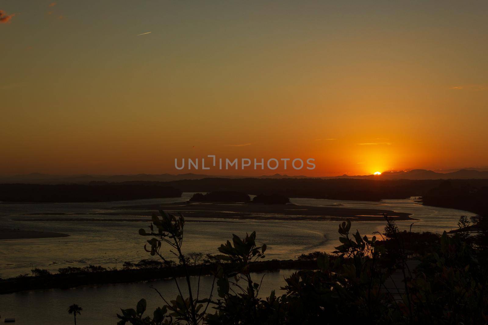 Flat sand dunes at delta of Nambucca river entering Pacific ocean through wide sandy beach of Australian coast around Nambucca heads town at sunset - aerial view by bettercallcurry