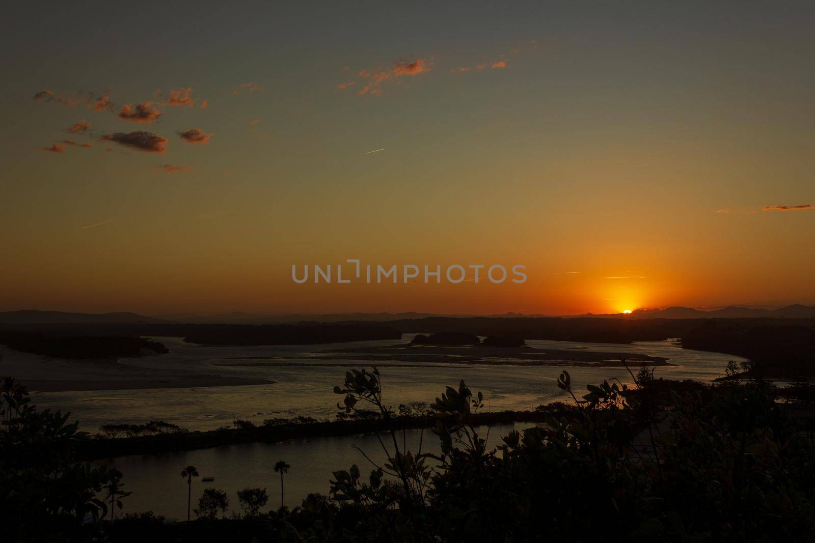 Flat sand dunes at delta of Nambucca river entering Pacific ocean through wide sandy beach of Australian coast around Nambucca heads town at sunset - aerial view by bettercallcurry