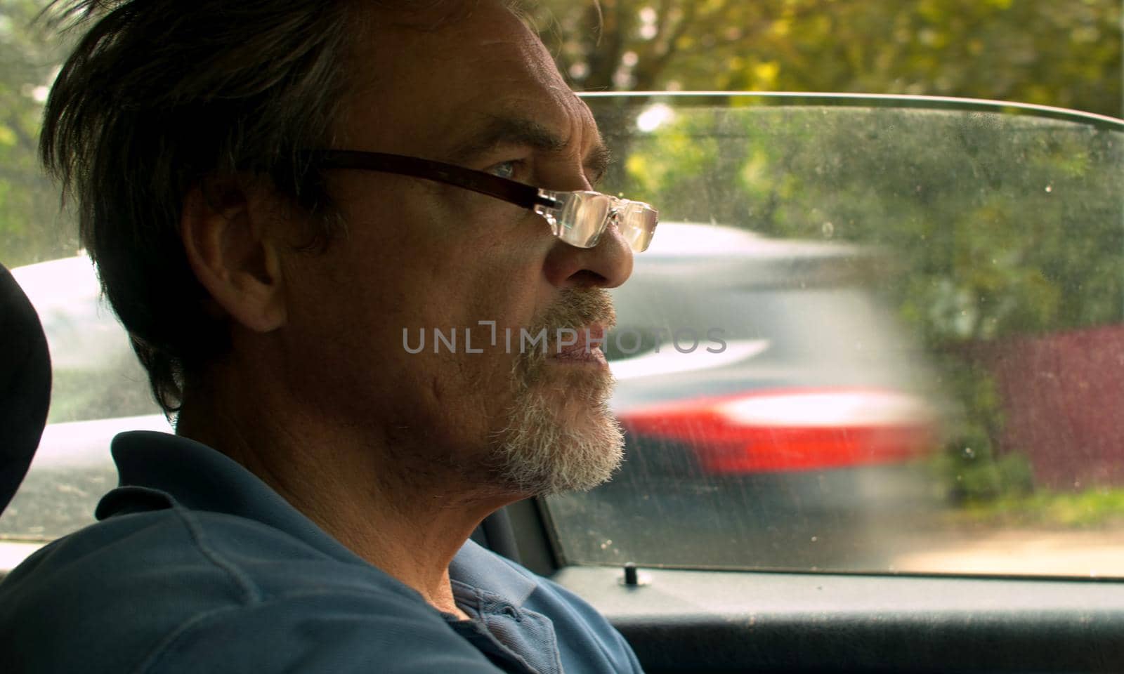 Close up portrait of handsome senior man driving a car. Shooting inside the car