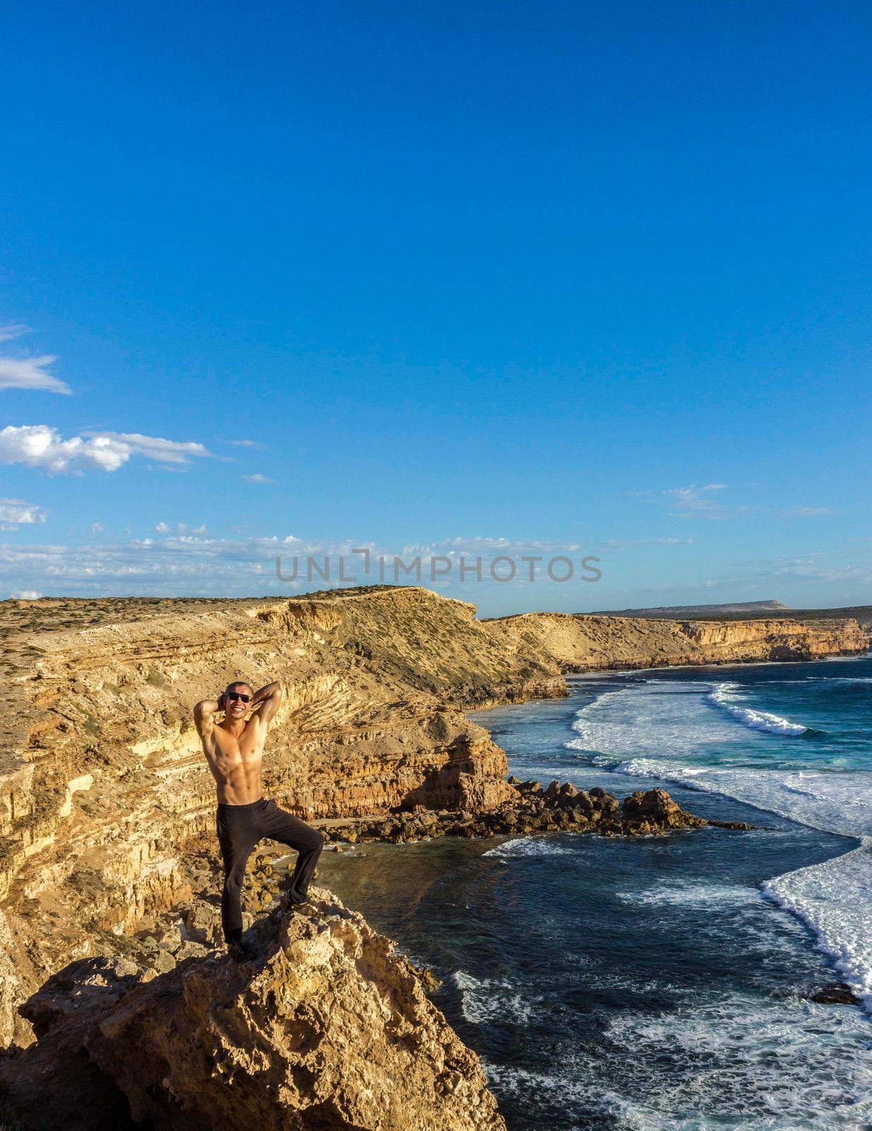 jung man standing on cliffs near port lincon at sunset, South Australia by bettercallcurry