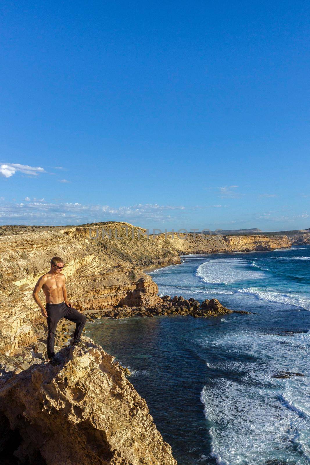 jung man standing on cliffs near port lincon at sunset, South Australia, australia