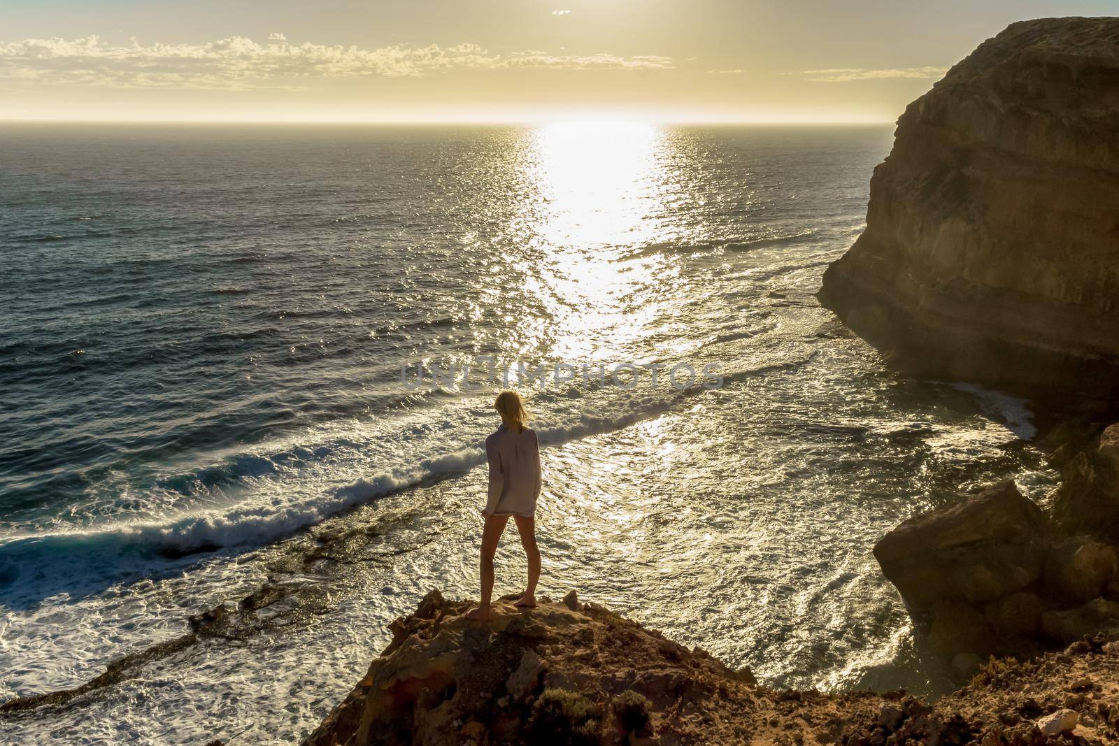 jung women standing on cliffs near port lincon at sunset, South Australia, australia