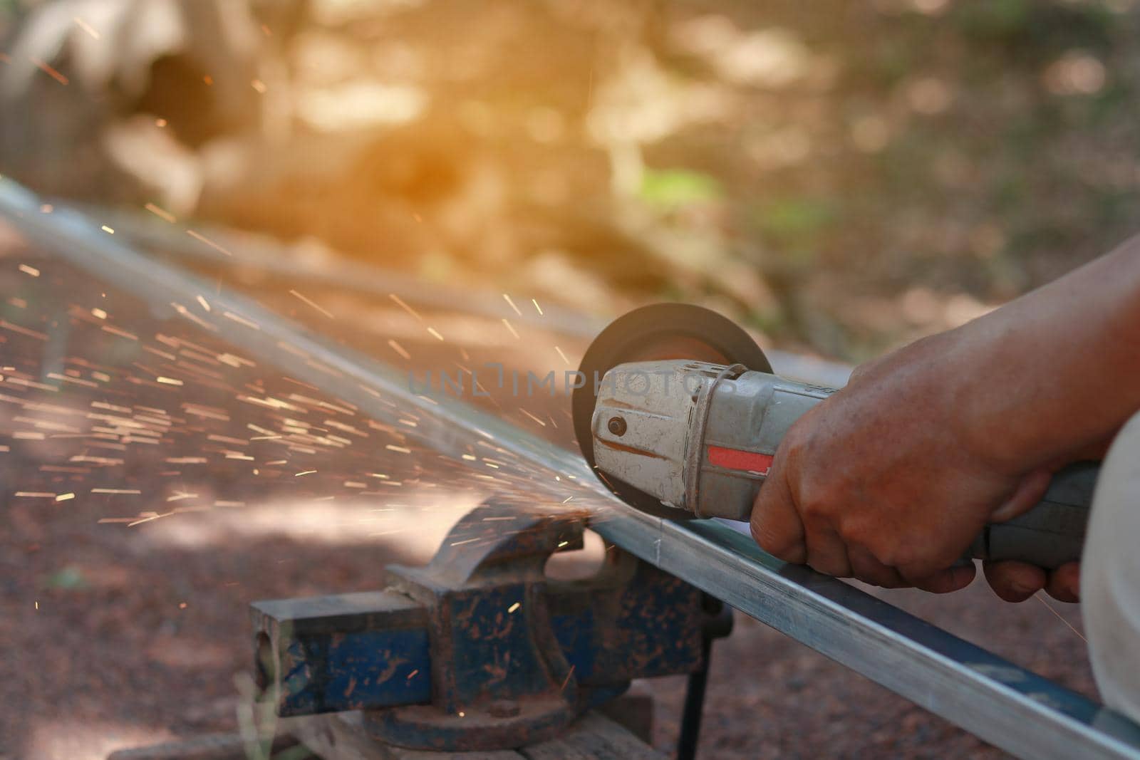 Technician cutting steel with tool in the workplace.