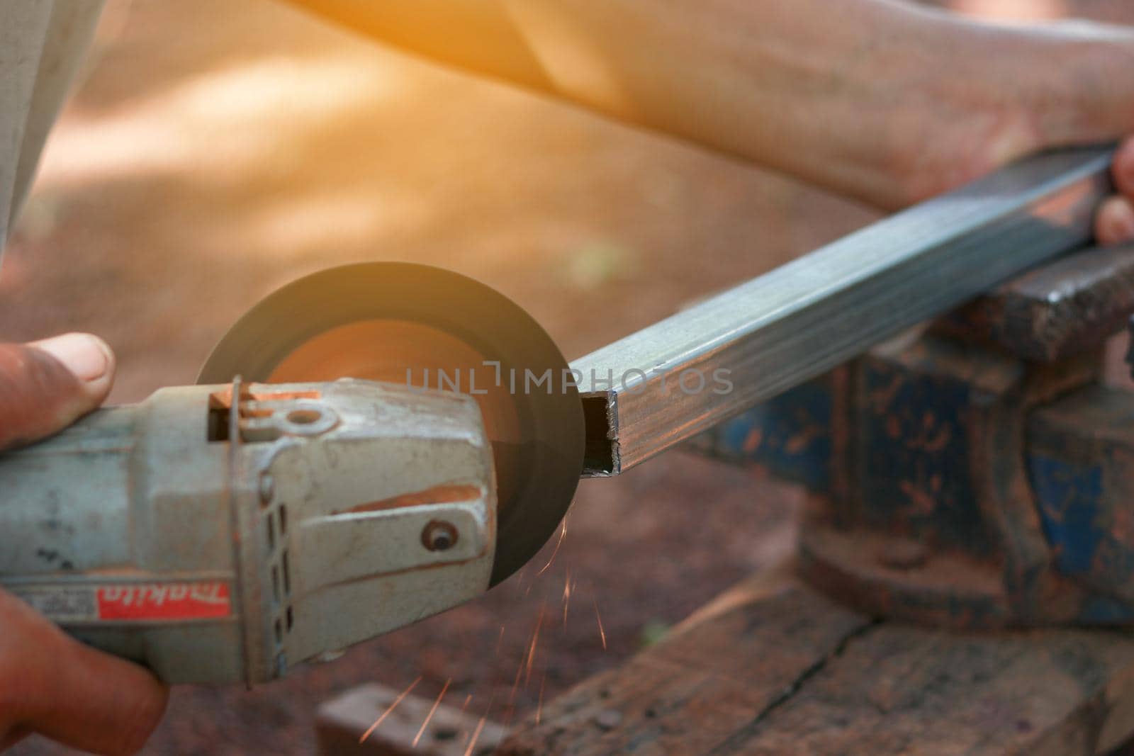 Technician cutting steel with tool in the workplace.