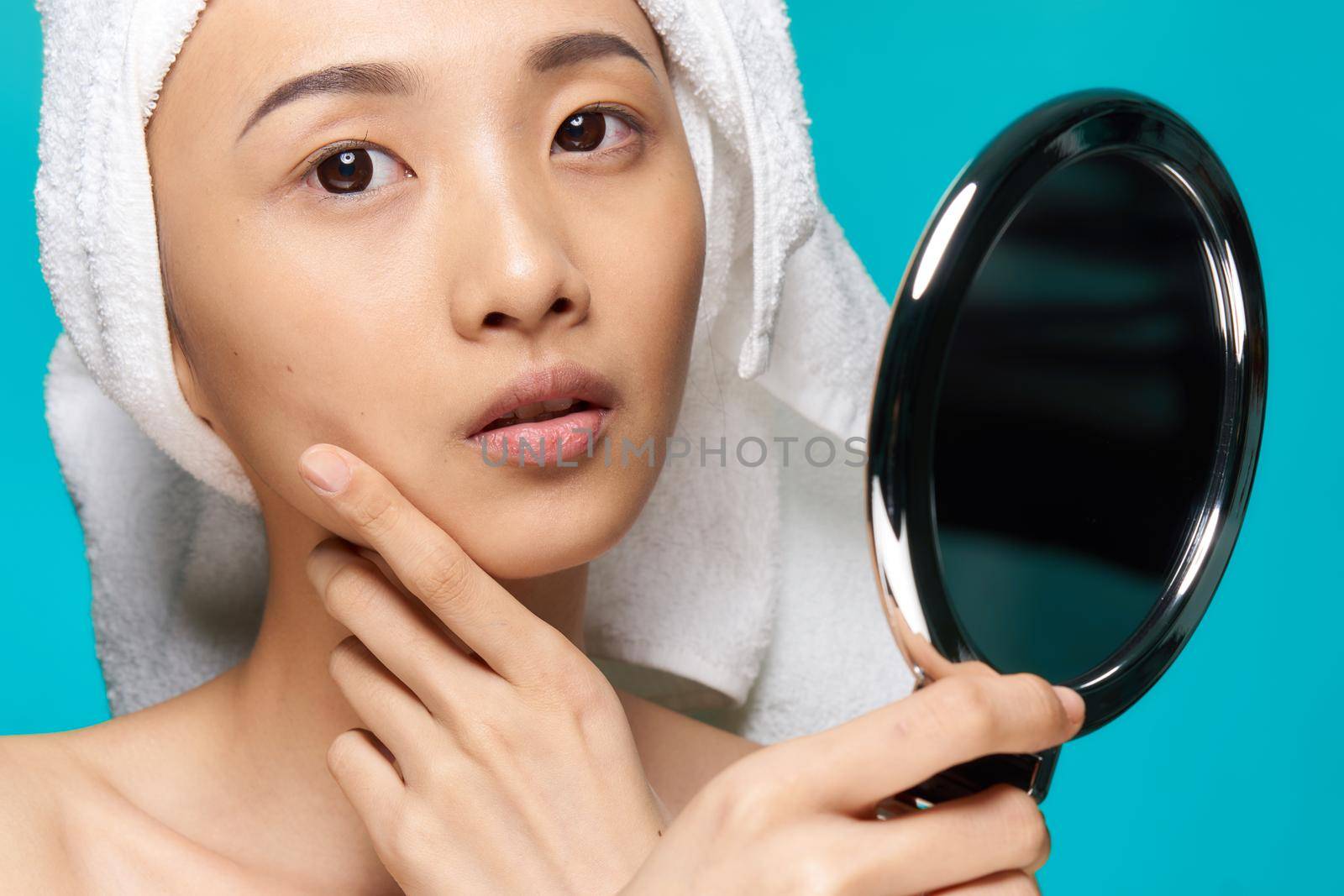 pretty asian woman looking in mirror naked shoulders clean skin after shower. High quality photo