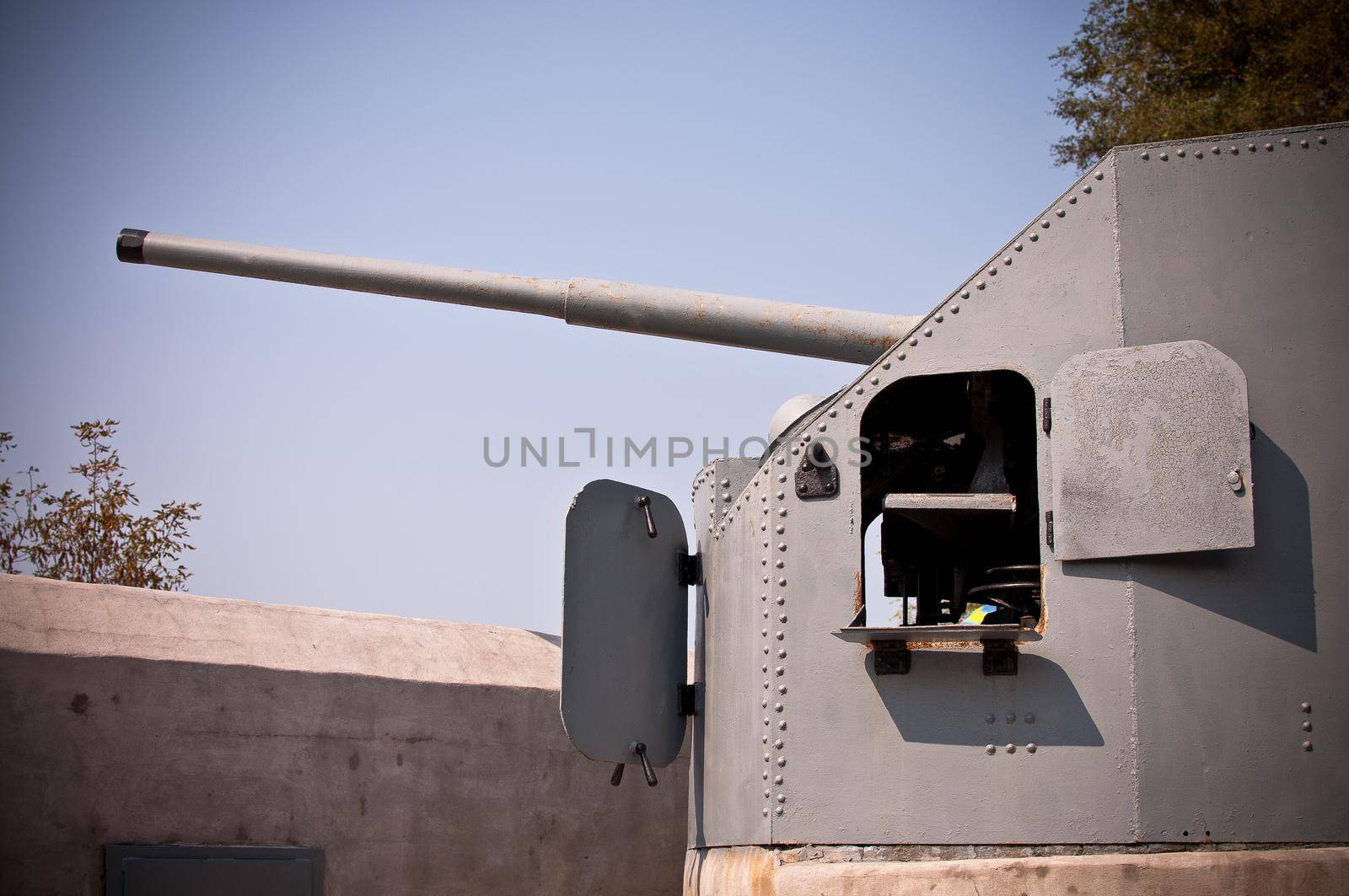 modern metal cannon for coastline or fortress defense. Barrel of gun mount on the background of sky.