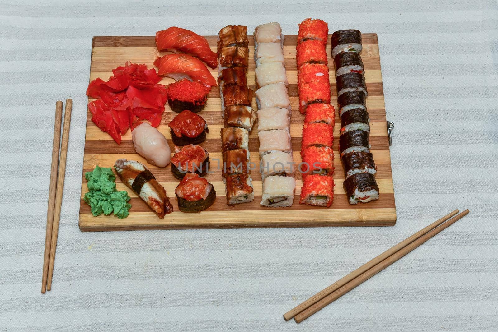 Top view of wooden platter with great set of delicious sushi and rolls.