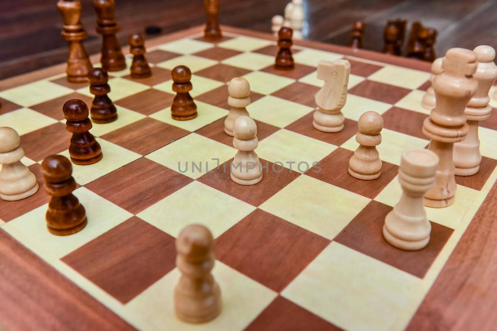 White and black chess pieces stand on board during a chess game.