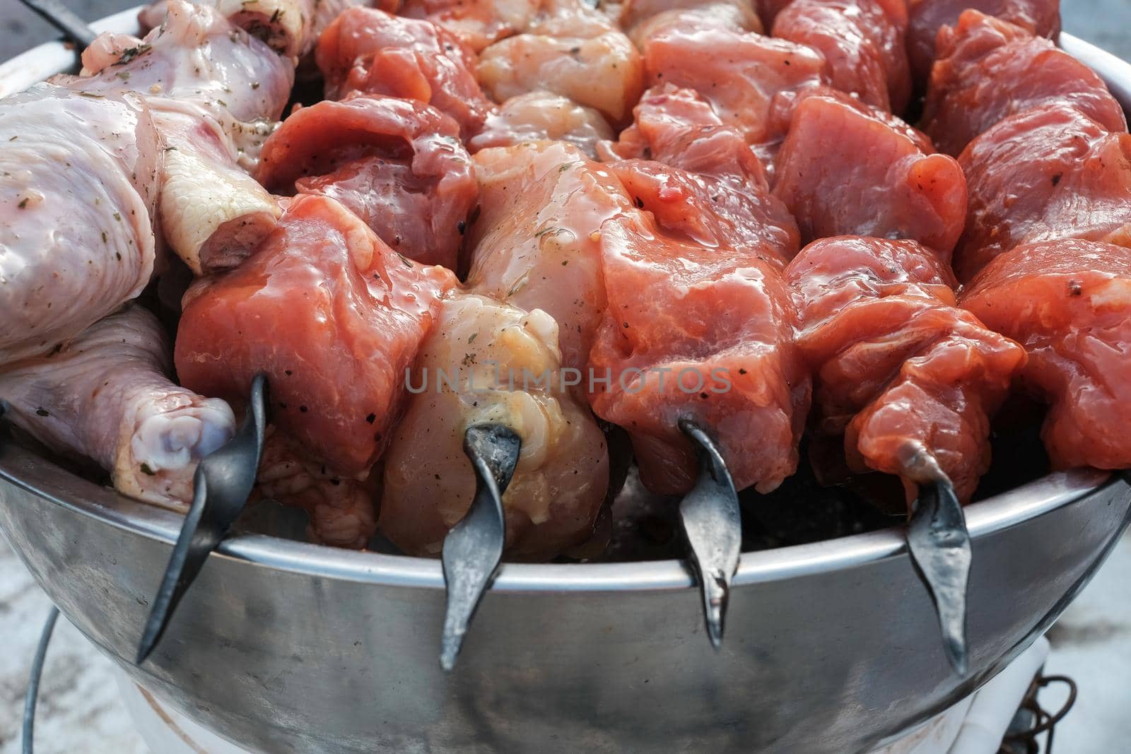 Raw pork skewers and chicken thighs cut into pieces and on skewers closeup.