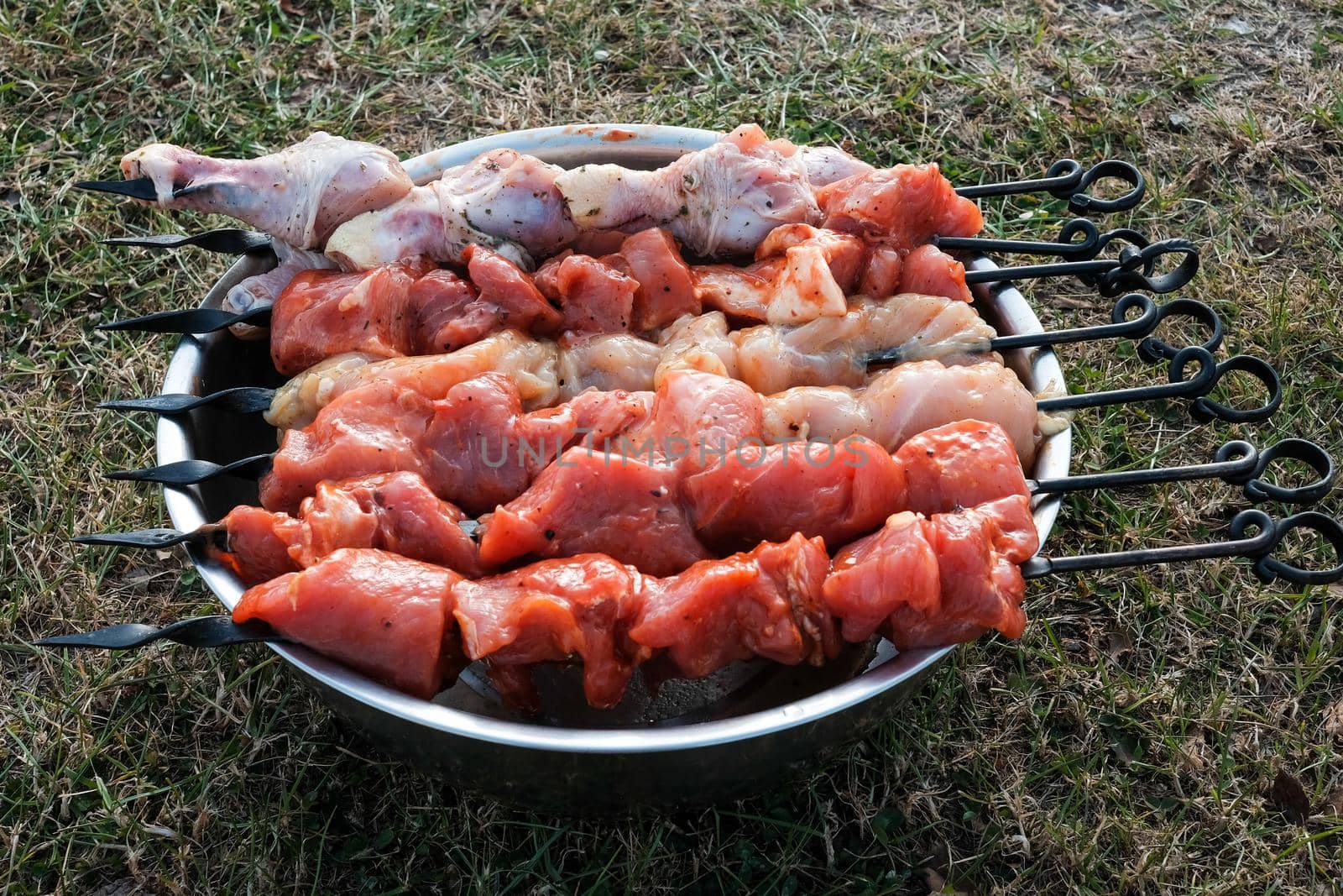 Raw pork skewers and chicken thighs, cut into pieces. meat on grill skewers. outdoor cooking on a picnic trip.