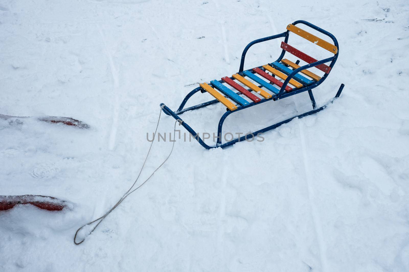 color wood and metal children sledges on the white snow.