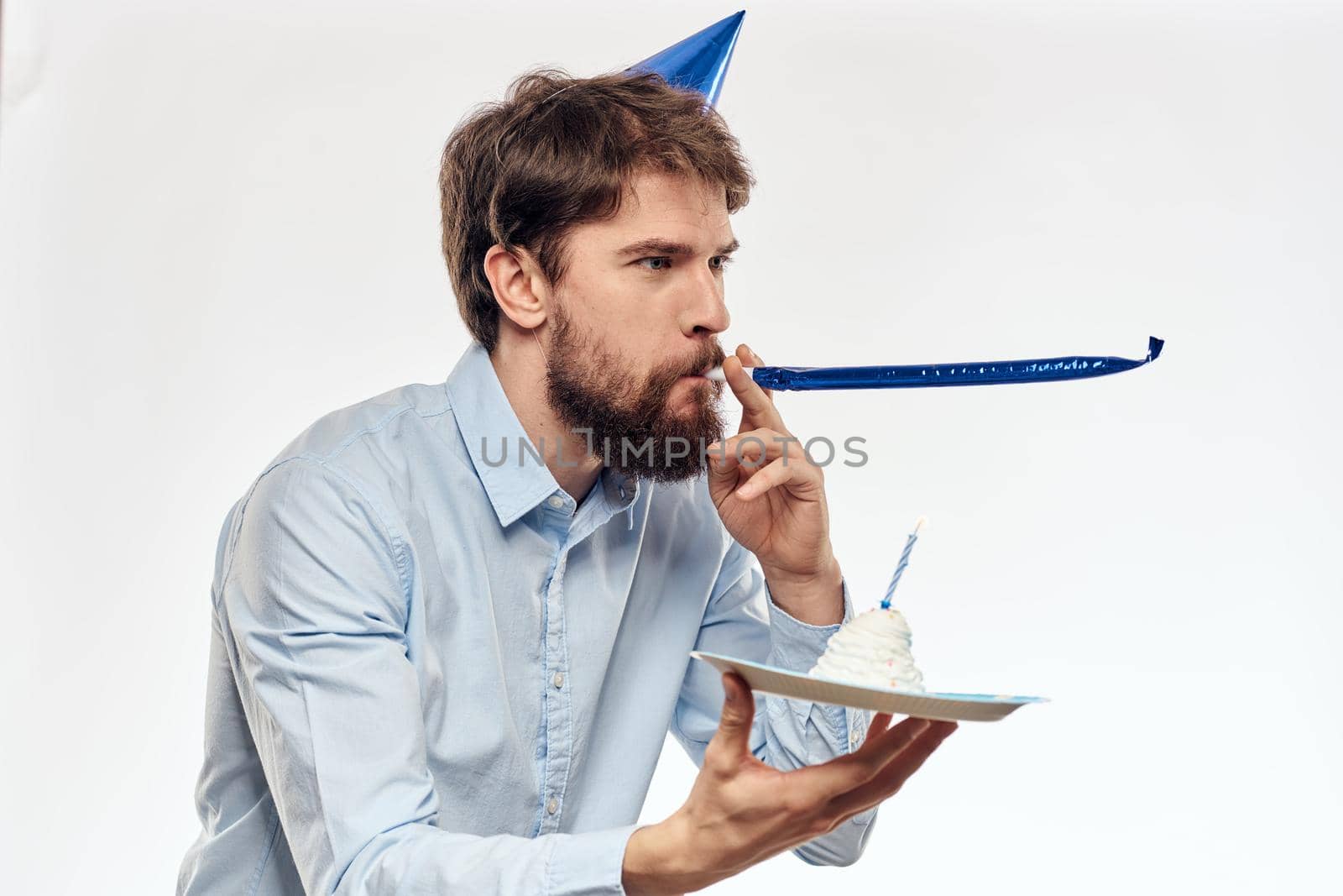 man with a cake plate and in a blue shirt on a light background birthday party corporate cap by SHOTPRIME