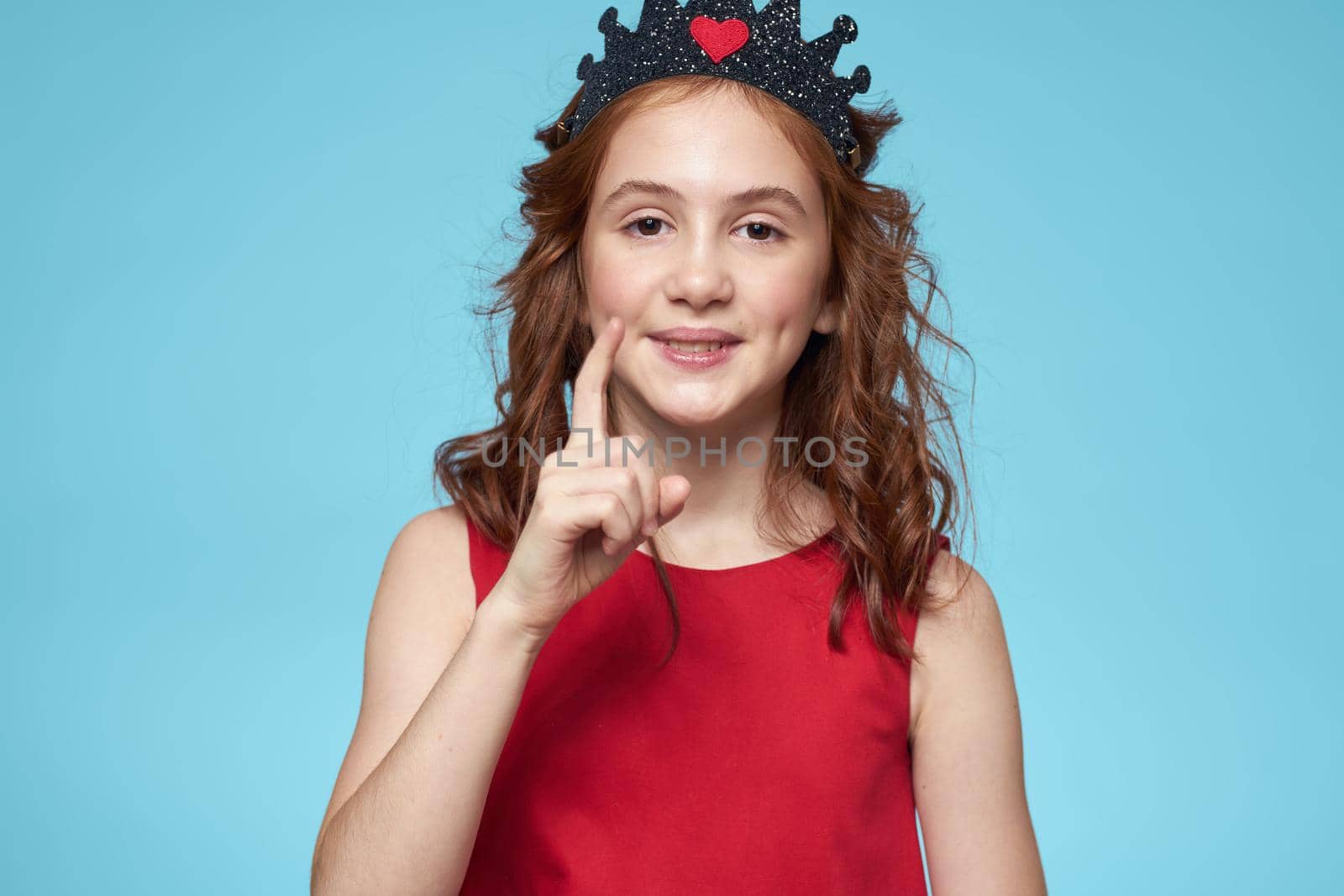 Girl in red dress with curly hair fun lifestyle blue background. High quality photo