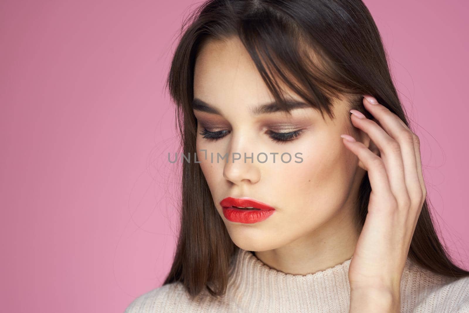 Beautiful brunette red lips white blouse close-up attractive view pink background. High quality photo